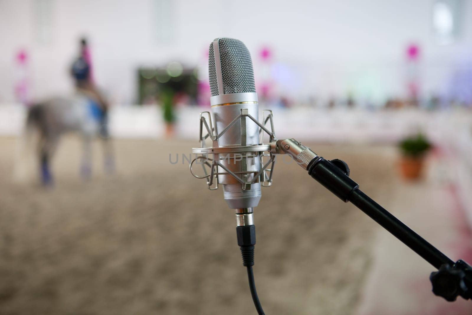 Classic metal microphone on a horse competition indoors, Spain