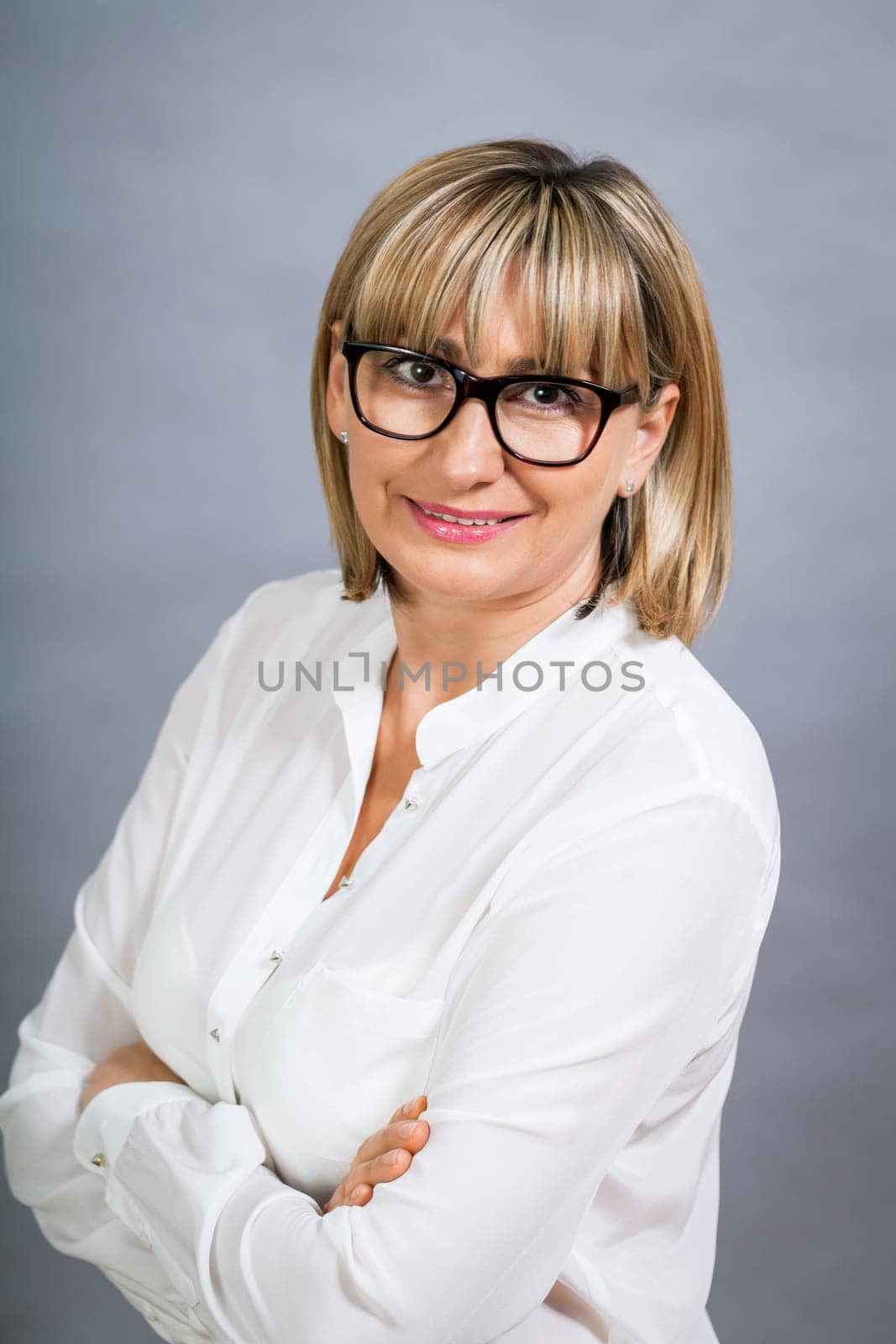 attractive adult woman in middle age with white blouse and brille