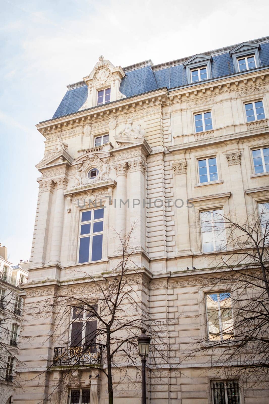 Exterior view of a Parisian townhouse in summer in front of a blue sky