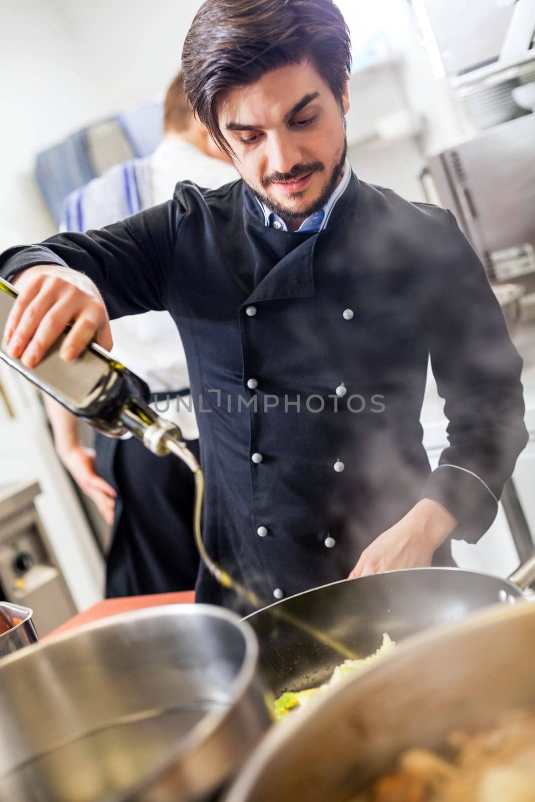 young adult chef in the restaurant kitchen while cooking at the herd preparation