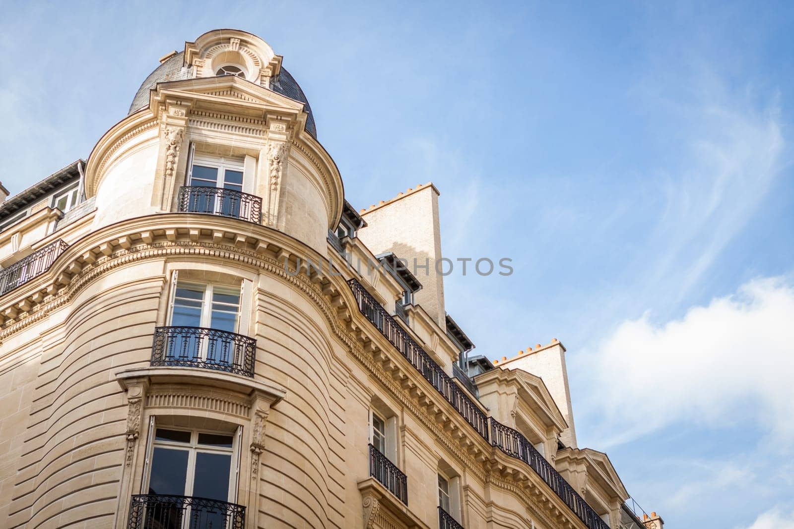 Exterior view of a Parisian townhouse in summer in front of a blue sky