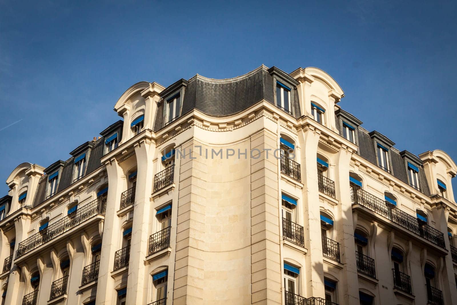 Exterior view of a Parisian townhouse in summer in front of a blue sky