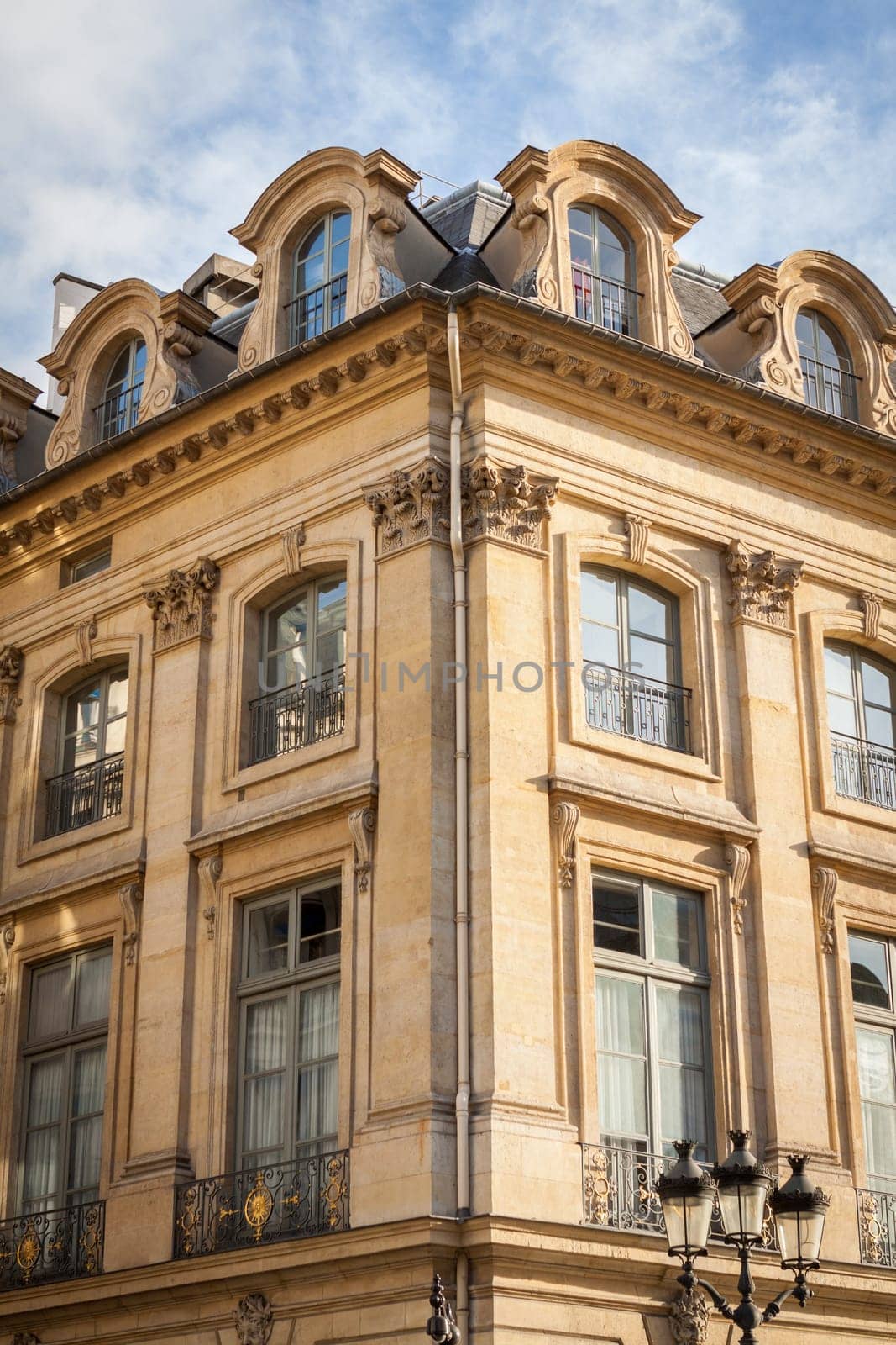 Exterior view of a Parisian townhouse in summer in front of a blue sky