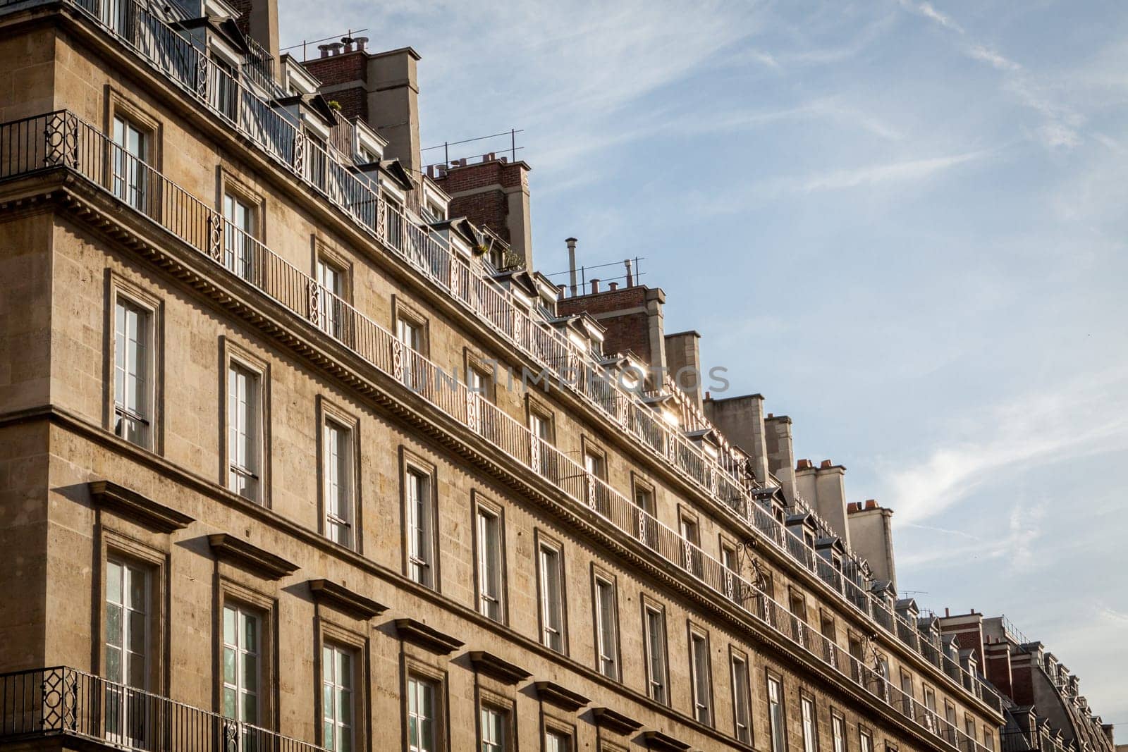 Exterior view of a Parisian townhouse in summer in front of a blue sky