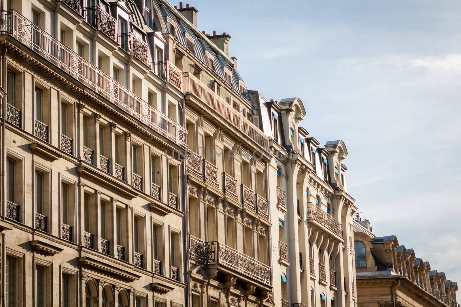 Exterior view of a Parisian townhouse in summer in front of a blue sky