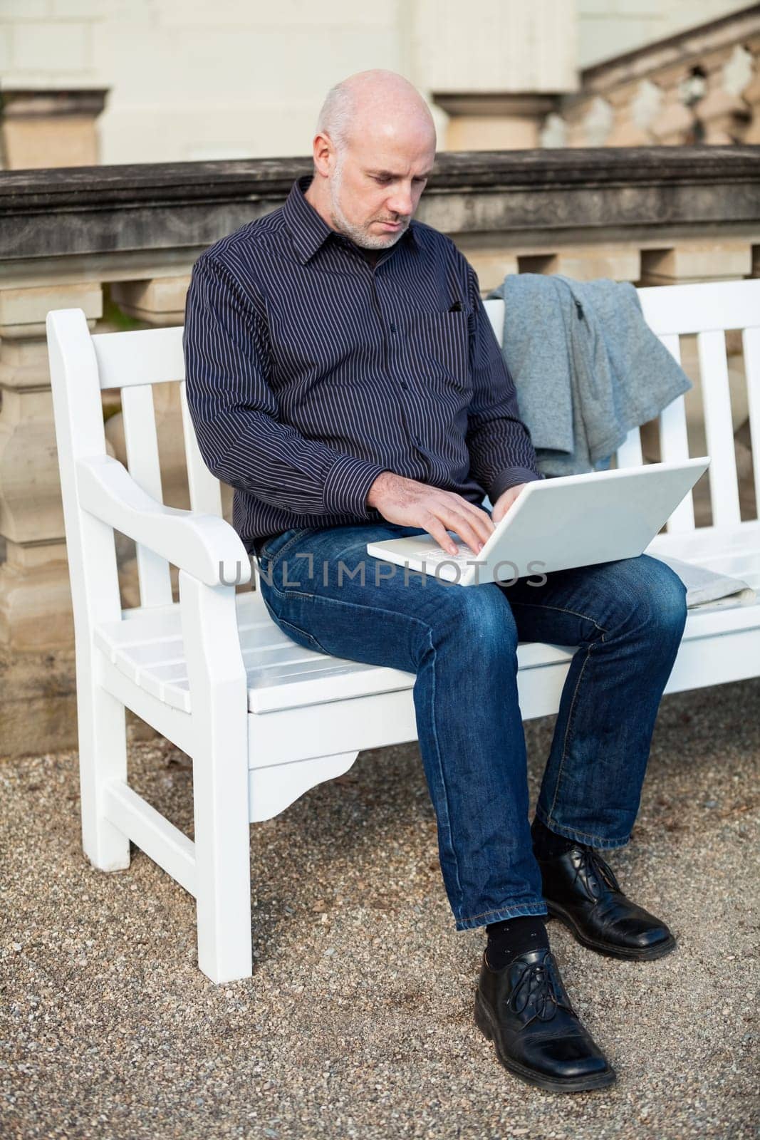 Businessman senior with notebook laptop during lunch break in summer outdoors