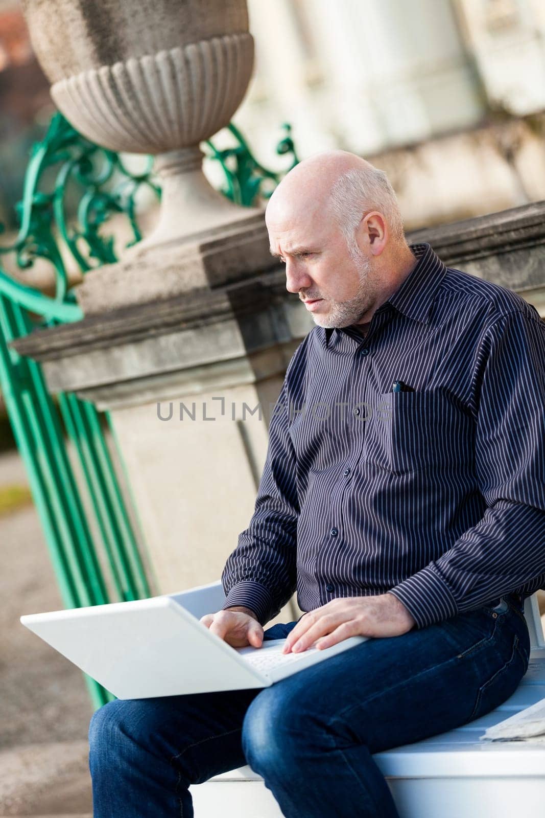 Businessman senior with notebook laptop during lunch break in summer outdoors