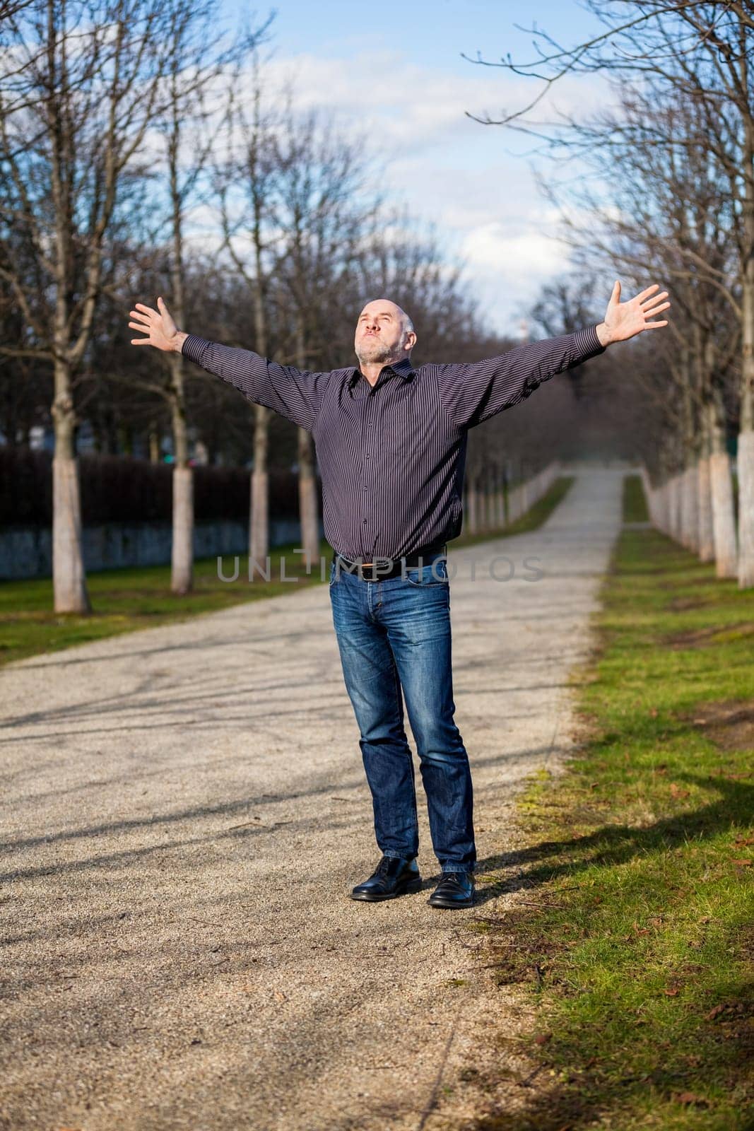Man middle Altres pensioner with outstretched arms enjoys the fresh air