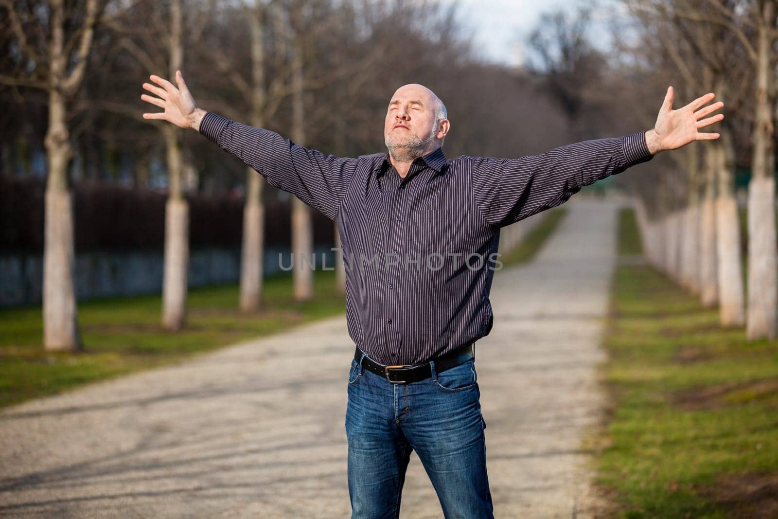 Man middle Altres pensioner with outstretched arms enjoys the fresh air