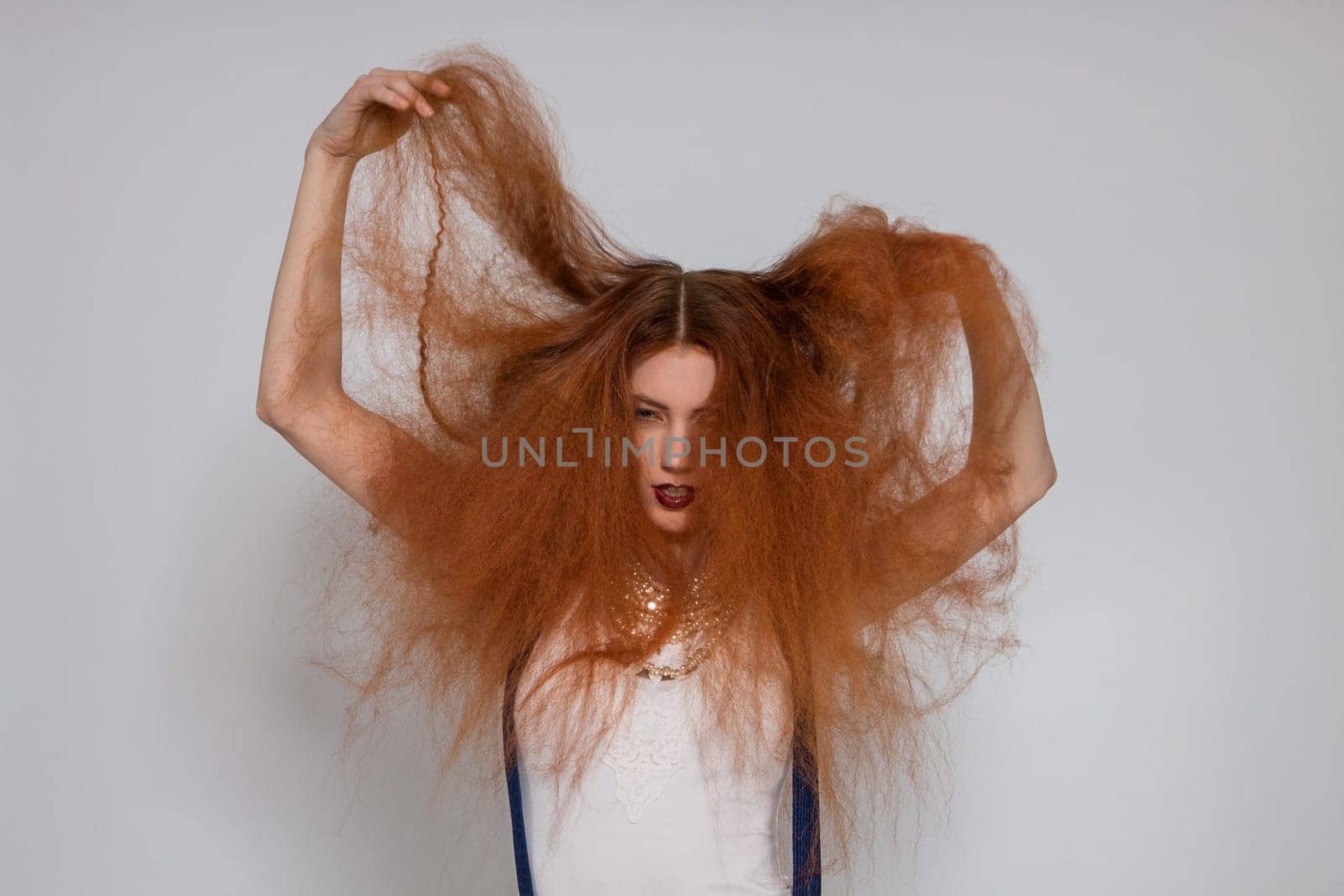 Young attractive pretty woman with long red hair and ripped hairstyle in portrait