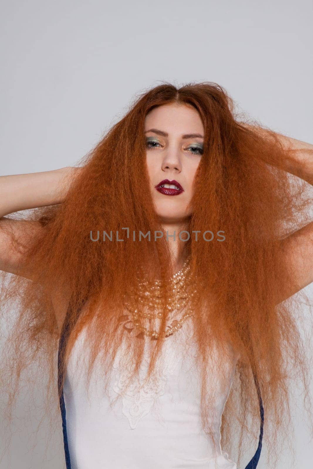 Young attractive pretty woman with long red hair and ripped hairstyle in portrait