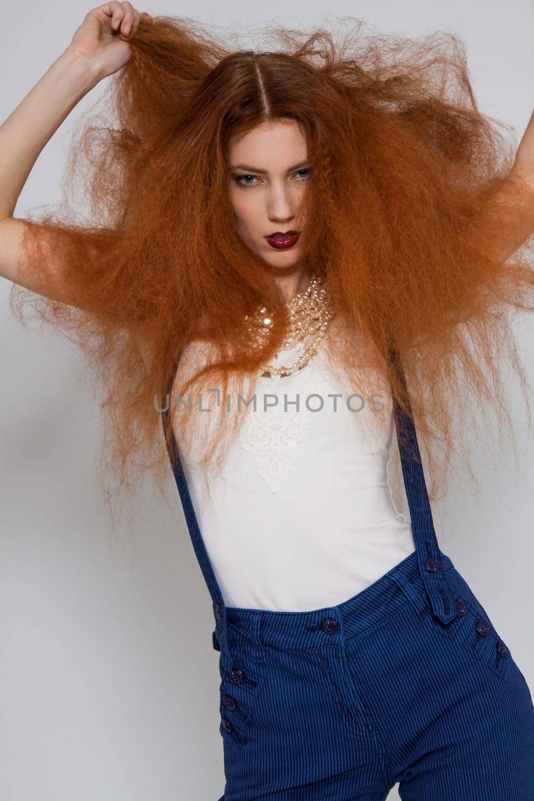 Young attractive pretty woman with long red hair and ripped hairstyle in portrait