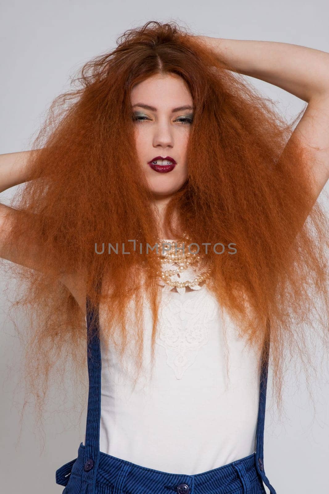 Young attractive pretty woman with long red hair and ripped hairstyle in portrait