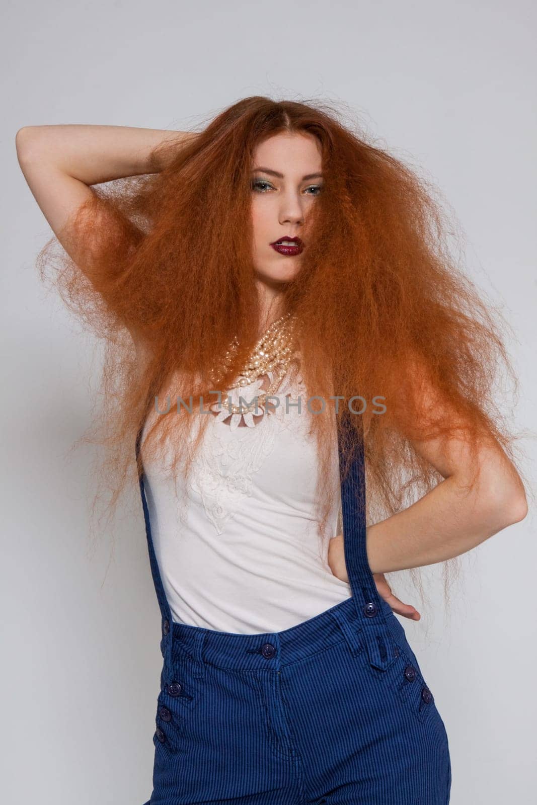 Young attractive pretty woman with long red hair and ripped hairstyle in portrait