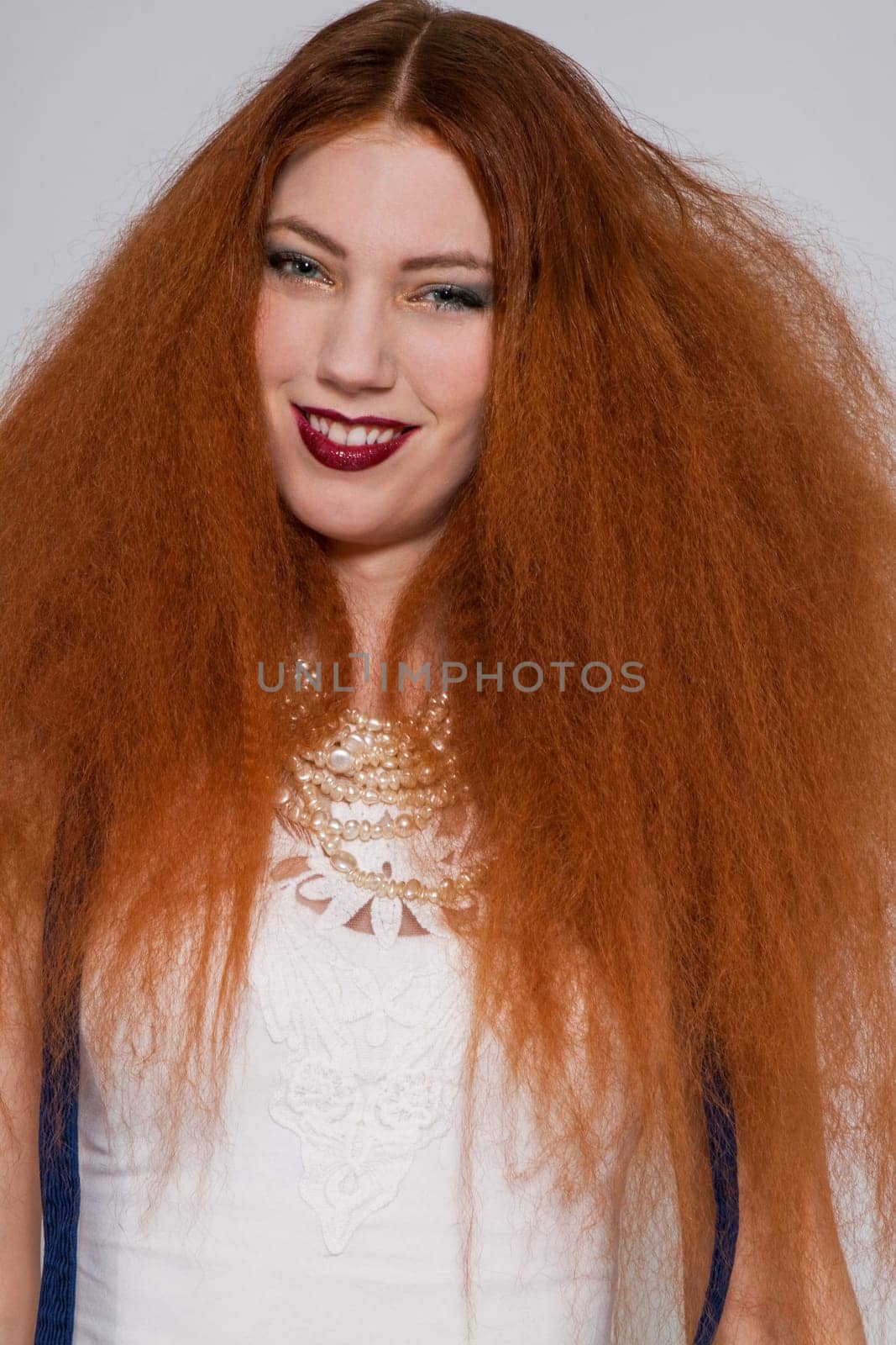 Young attractive pretty woman with long red hair and ripped hairstyle in portrait