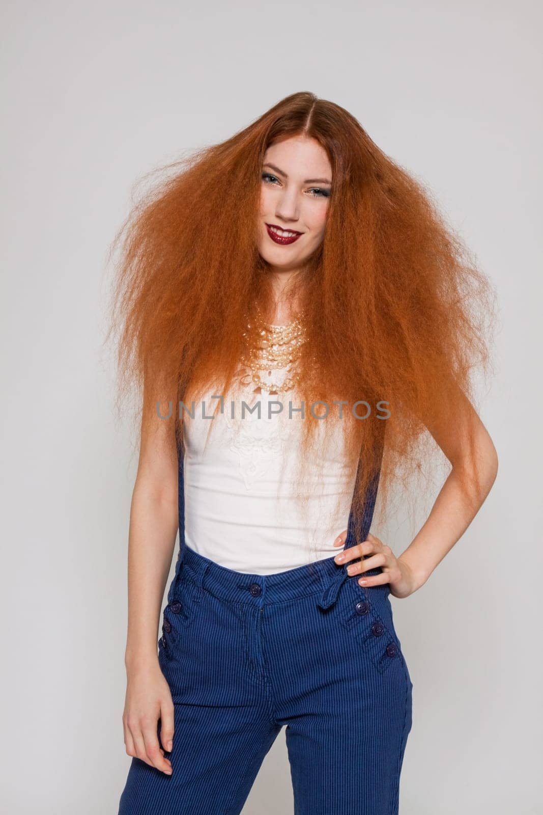 Young attractive pretty woman with long red hair and ripped hairstyle in portrait