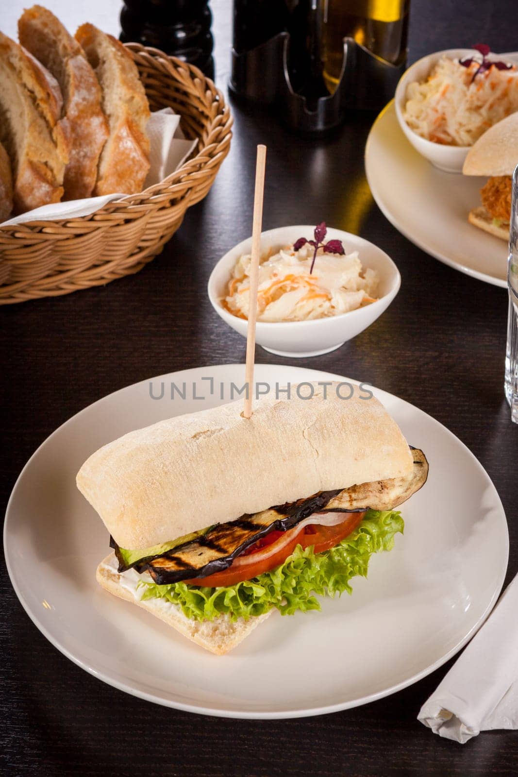 Vegetarian vegan hamburger with aubergine tomato and salad in a ciabatta bun