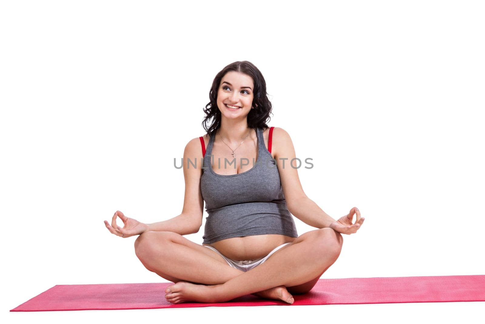Attractive pregnant young woman makes yoga isolated against white background