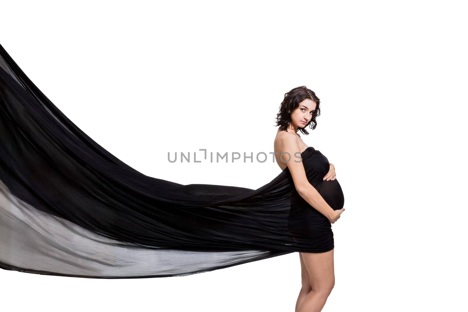 Young attractive pregnant woman wrapped in black fabric insulated against white background