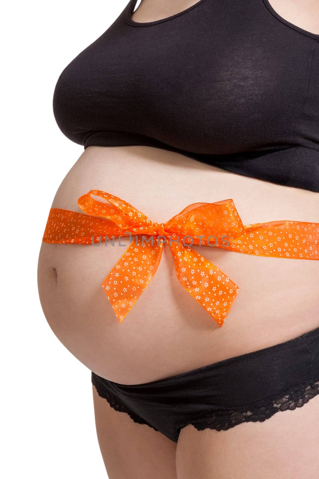 Young pregnant woman with orange bow around her belly as close-up isolated against white background