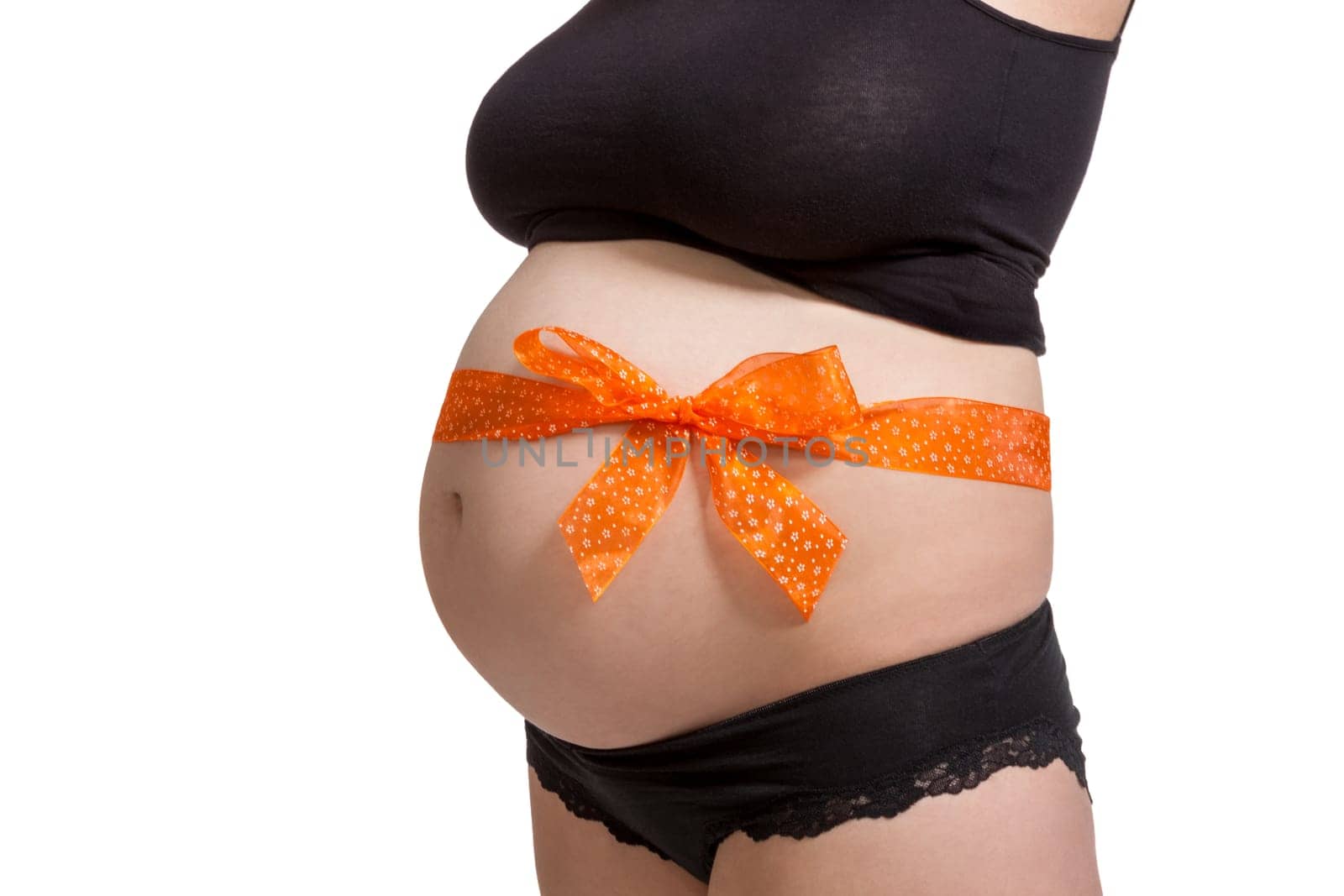 Young pregnant woman with orange bow around her belly as close-up isolated against white background