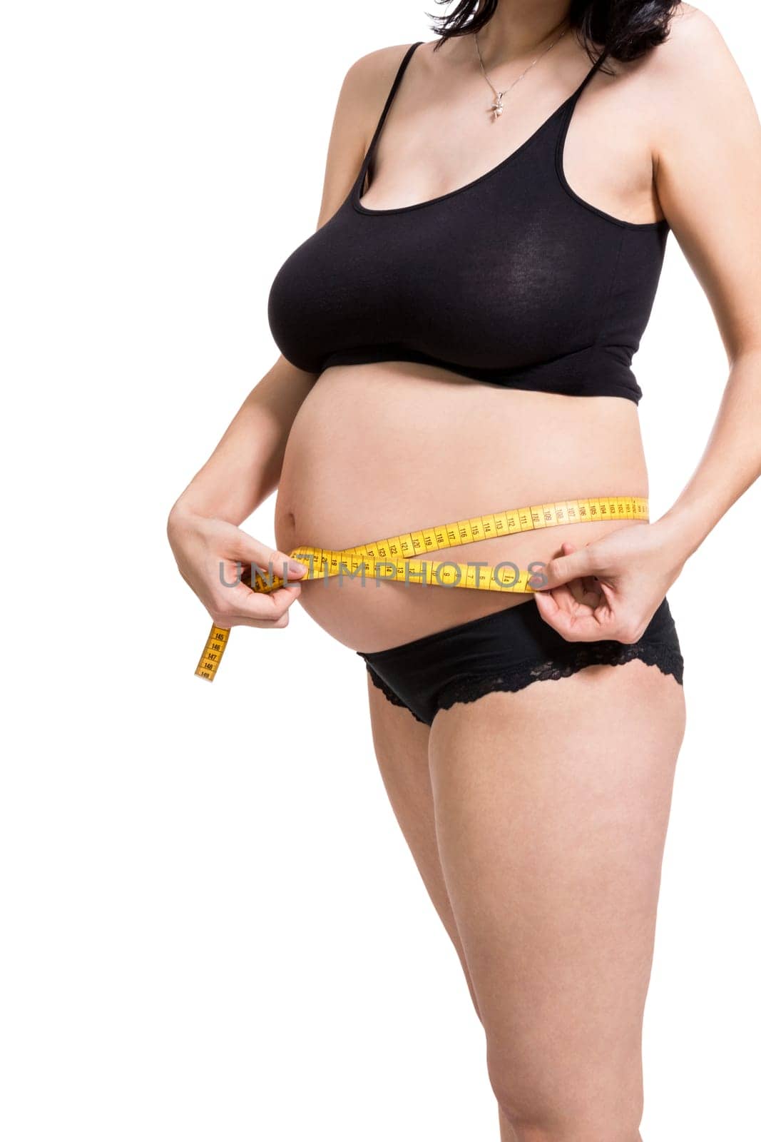 Pregnant woman with a measuring tape measures her girth on her abdomen isolated against a white background