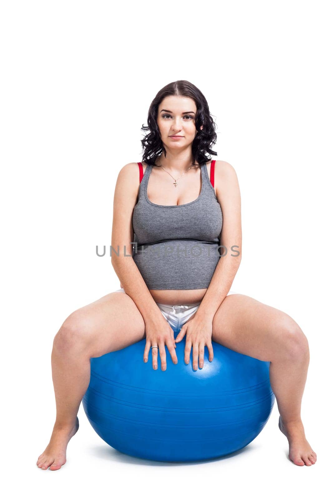 Attractive pregnant woman on a blue gymnastics ball to prepare for the brew