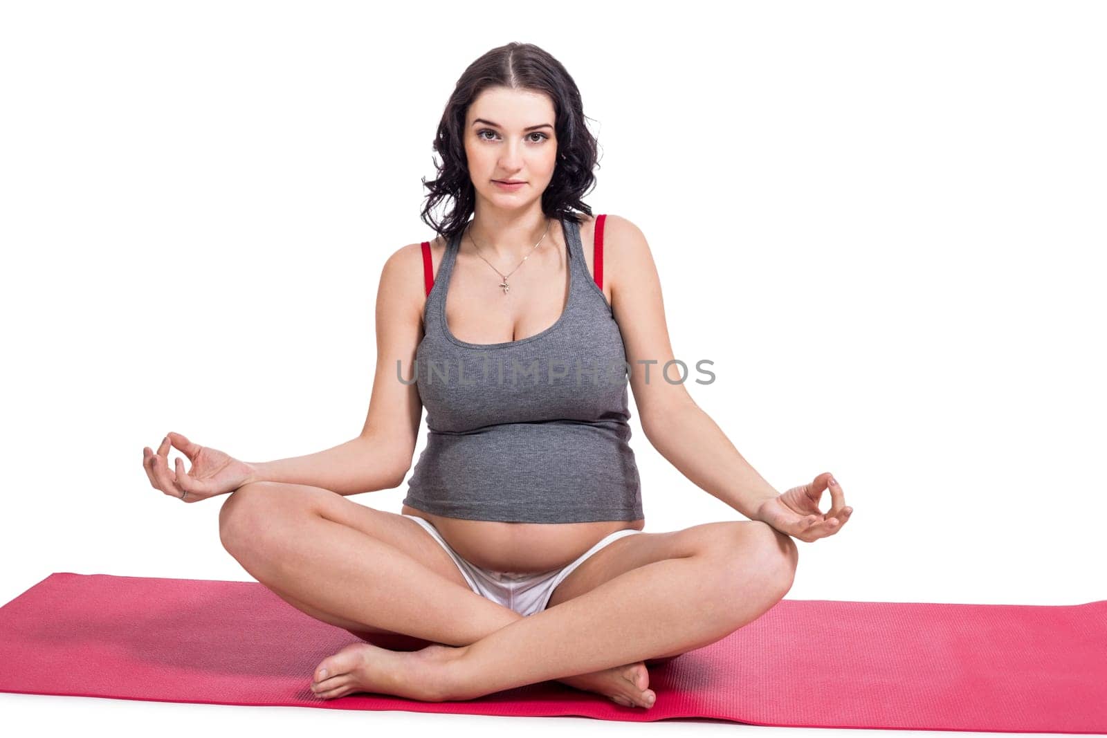Attractive pregnant young woman makes yoga isolated against white background