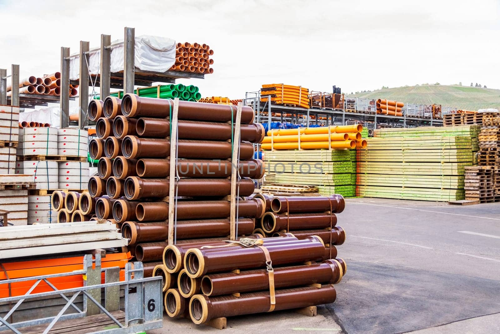 Different pipes for industry stacked in one warehouse in the open air