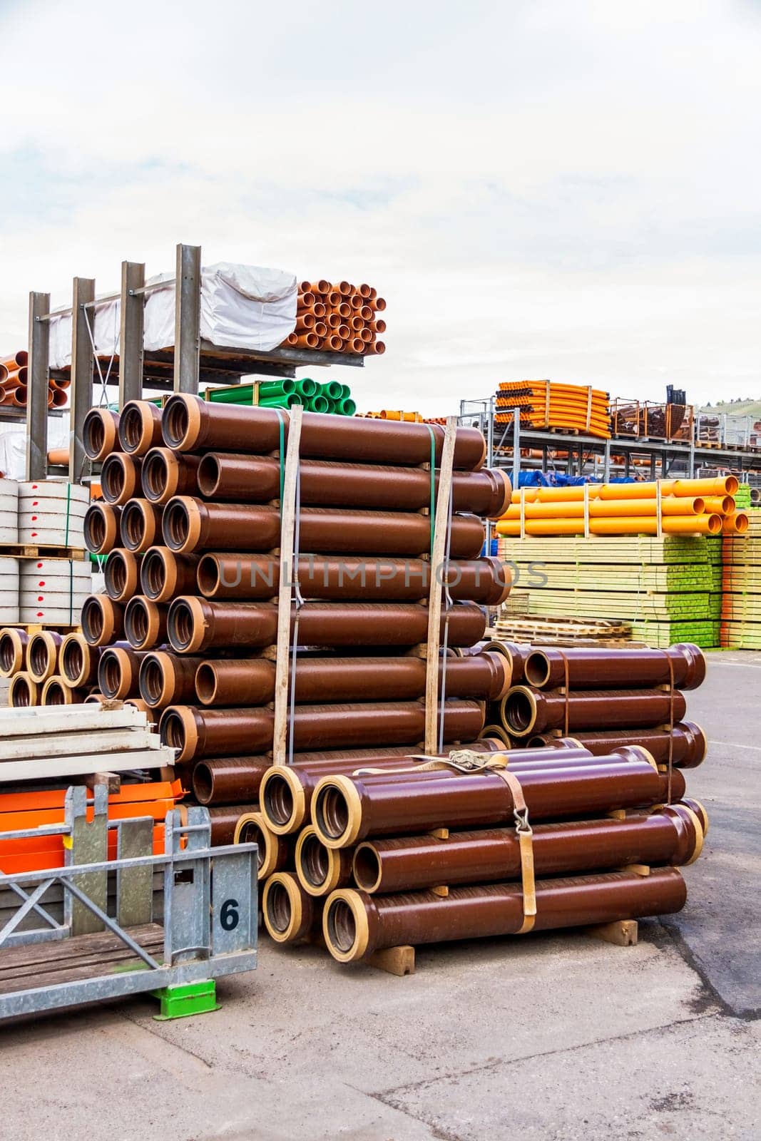 Different pipes for industry stacked in one warehouse in the open air