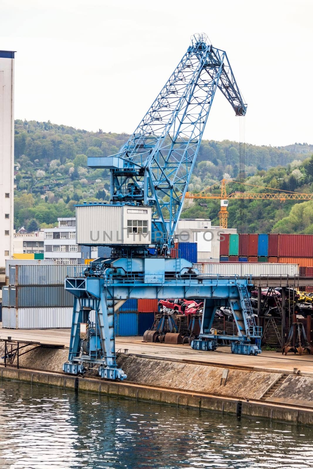 Dock in the port with stacked containers at the dock for import and export cargo with blue sky