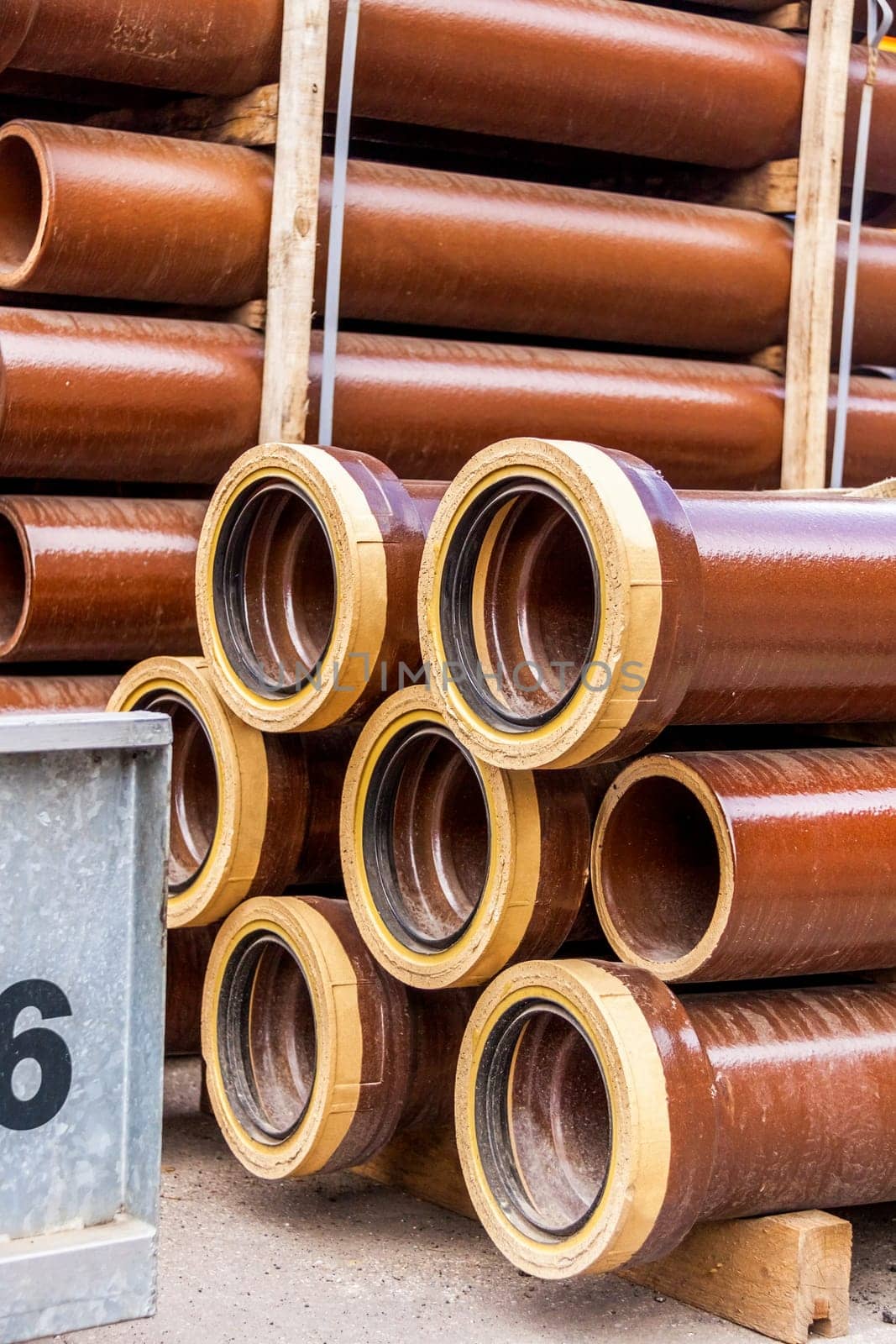 Different pipes for industry stacked in one warehouse in the open air