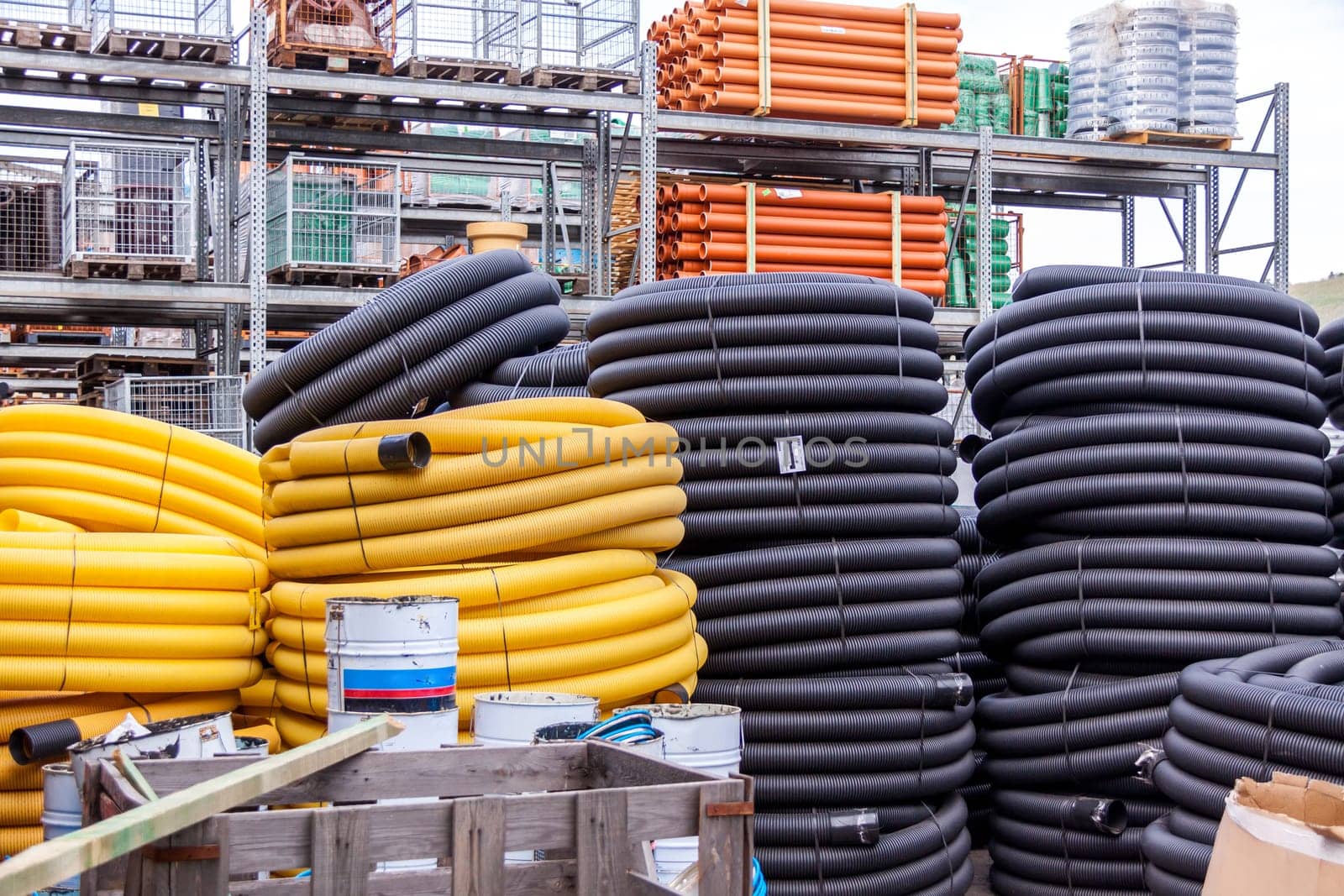 Rolled yellow and black plastic rubber hoses stored in industrial area