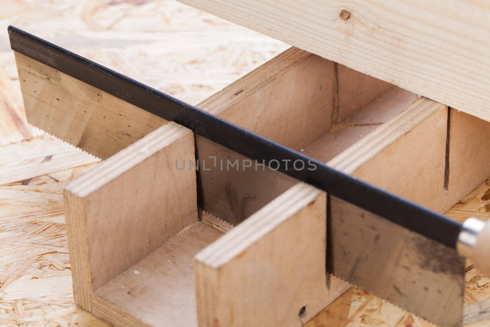 Wood with angle cutter and saw in a workshop close-up detail