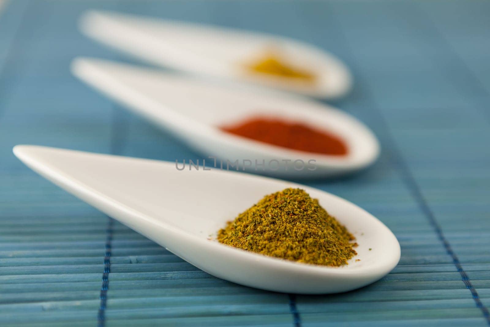 dried spices in porcelain bowls on a blue background