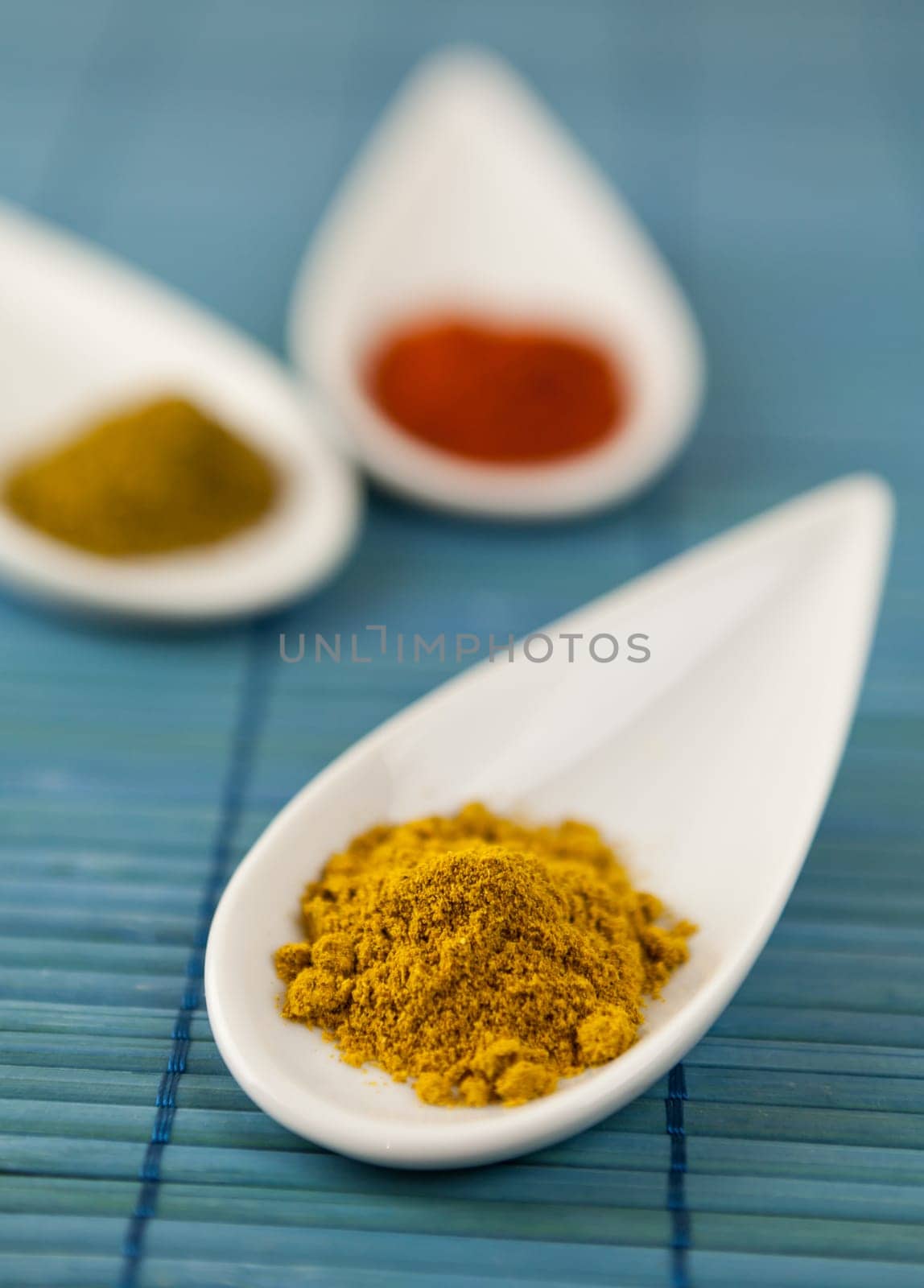 dried spices in porcelain bowls on a blue background