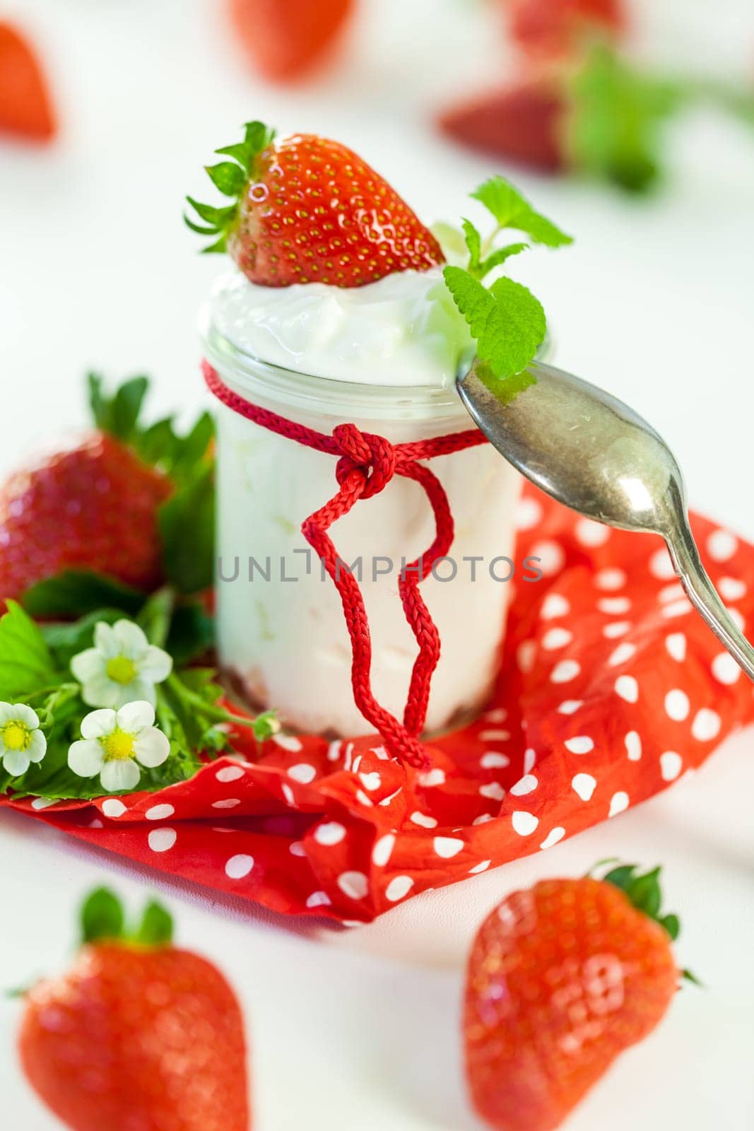 Fresh yoghurt with strawberries in a glass insulated on a white background