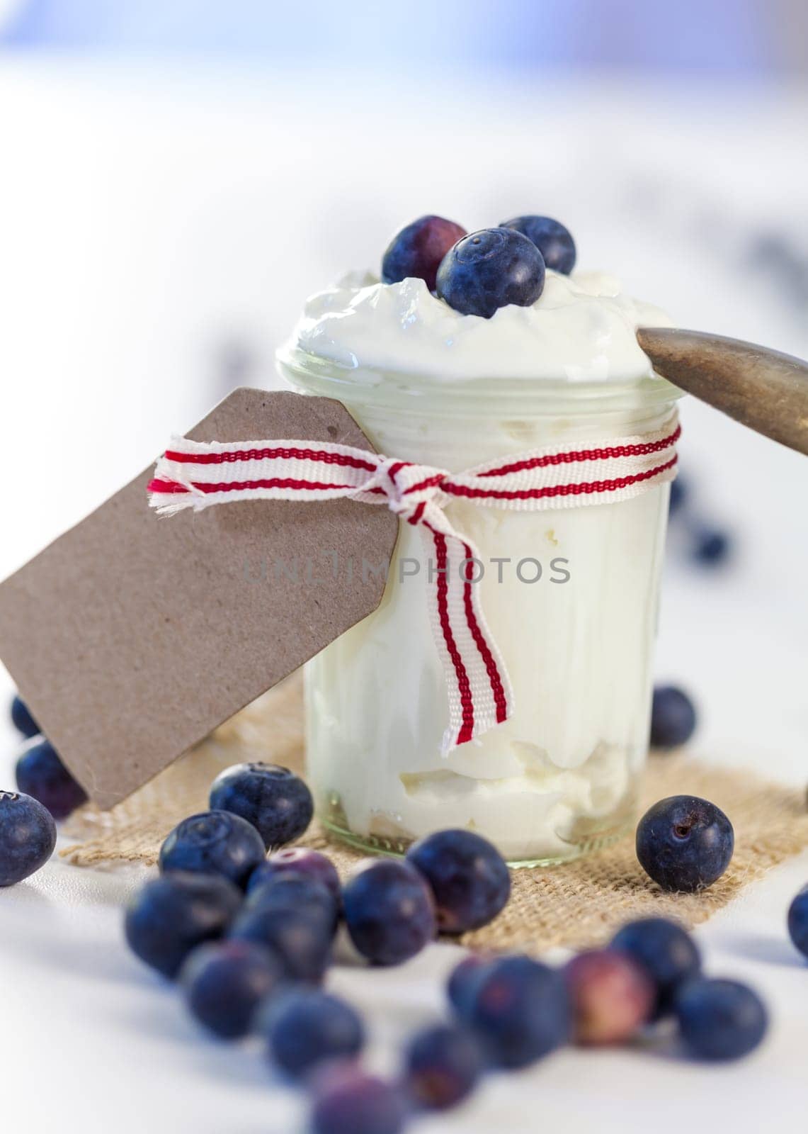 Glass with yoghurt and fresh blueberries blueberries for breakfast and for dessert