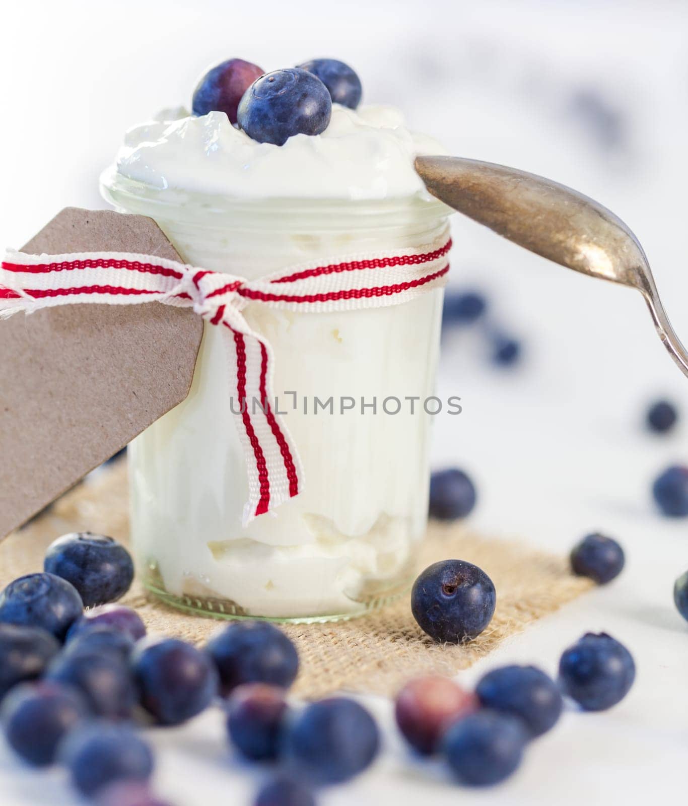 Glass with yoghurt and fresh blueberries blueberries for breakfast and for dessert