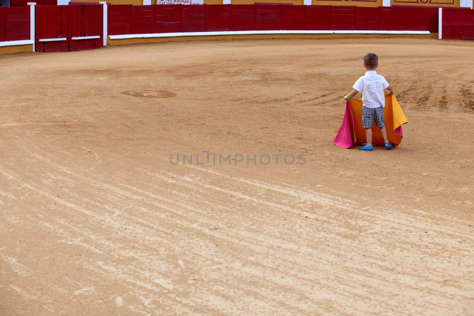 Unidentified child on arena pretending performs a bullfight,  Badajoz, Spain