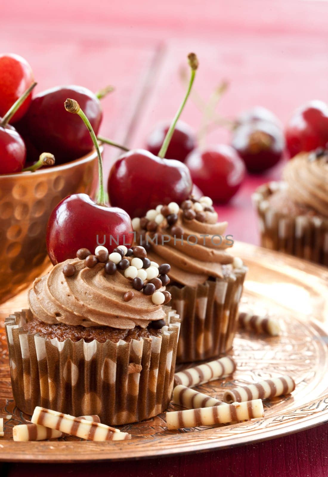 Chocolate cupcakes with buttercream and fresh cherries