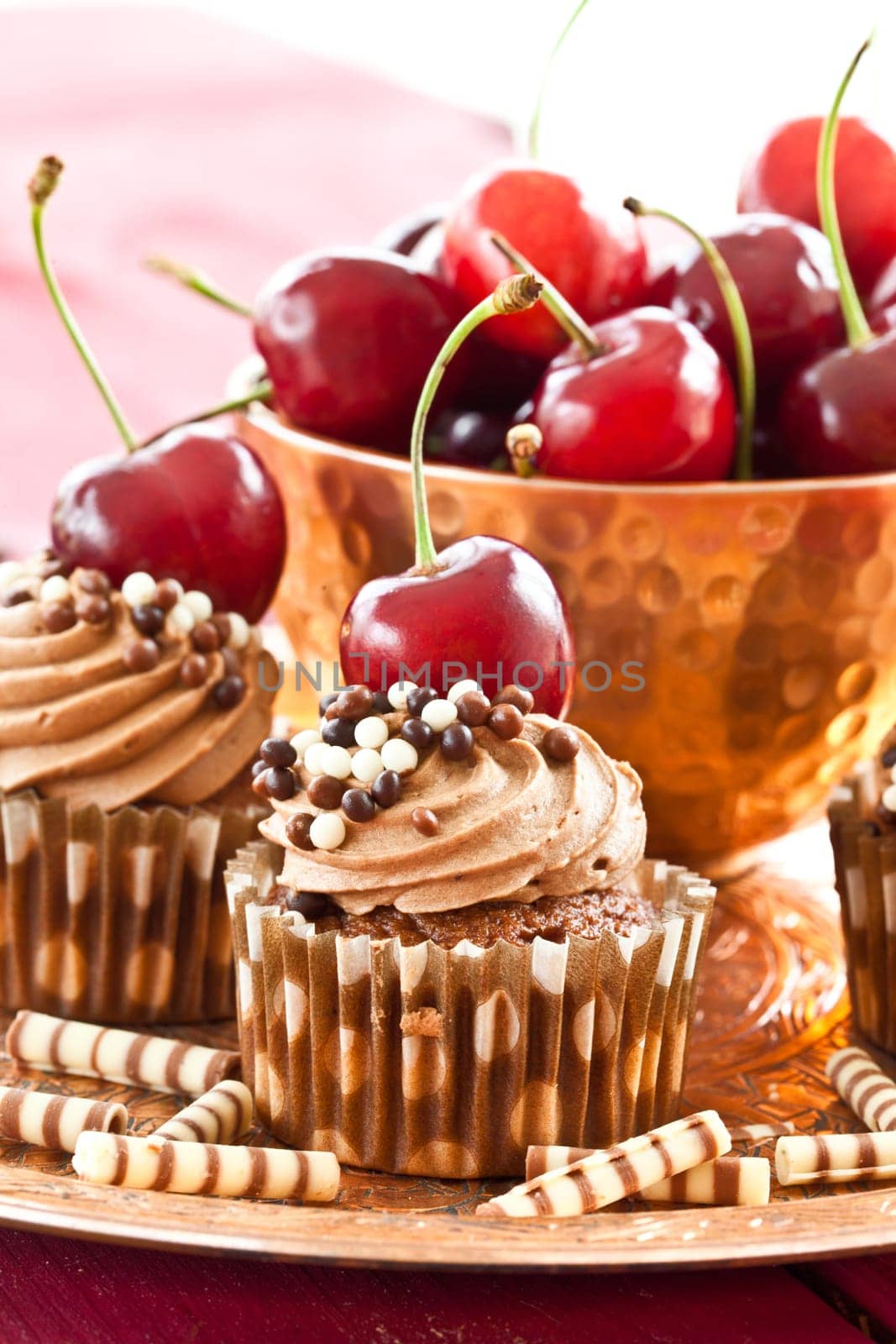 Chocolate cupcakes with buttercream and fresh cherries