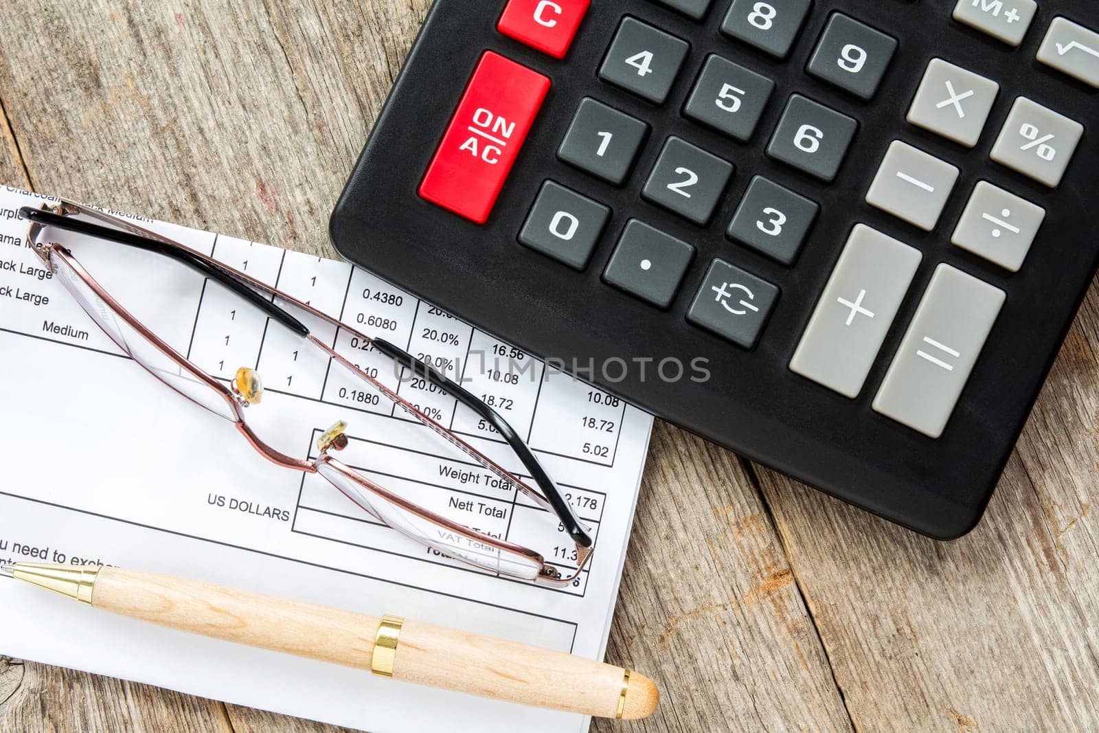 Invoice with balance due, calculator,pen and glasses