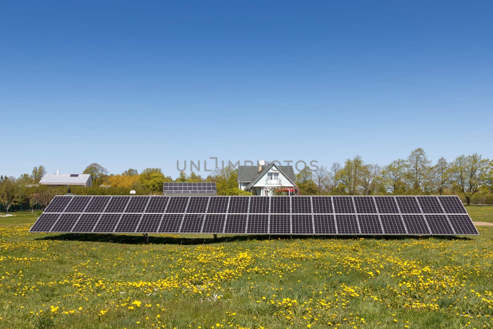 A set of dark blue solar panels in a grass field