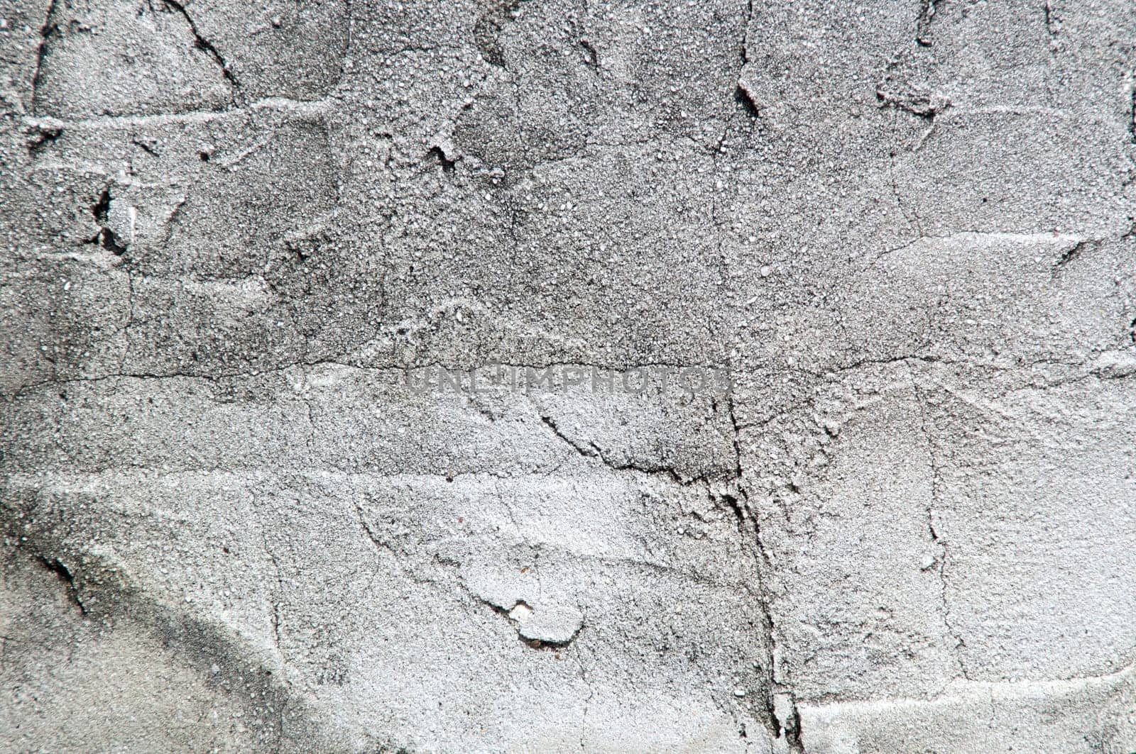Close up of old textured cement wall in sunshine.