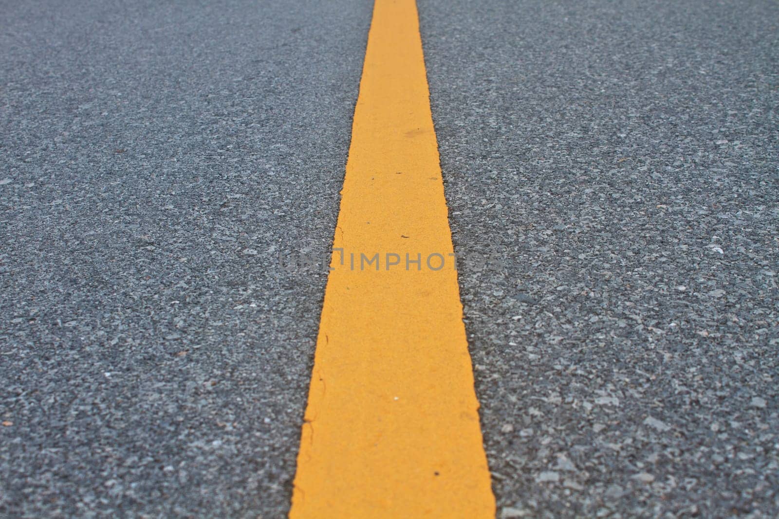 asphalt road with marking lines and tire tracks. Close up photo with selective focus
