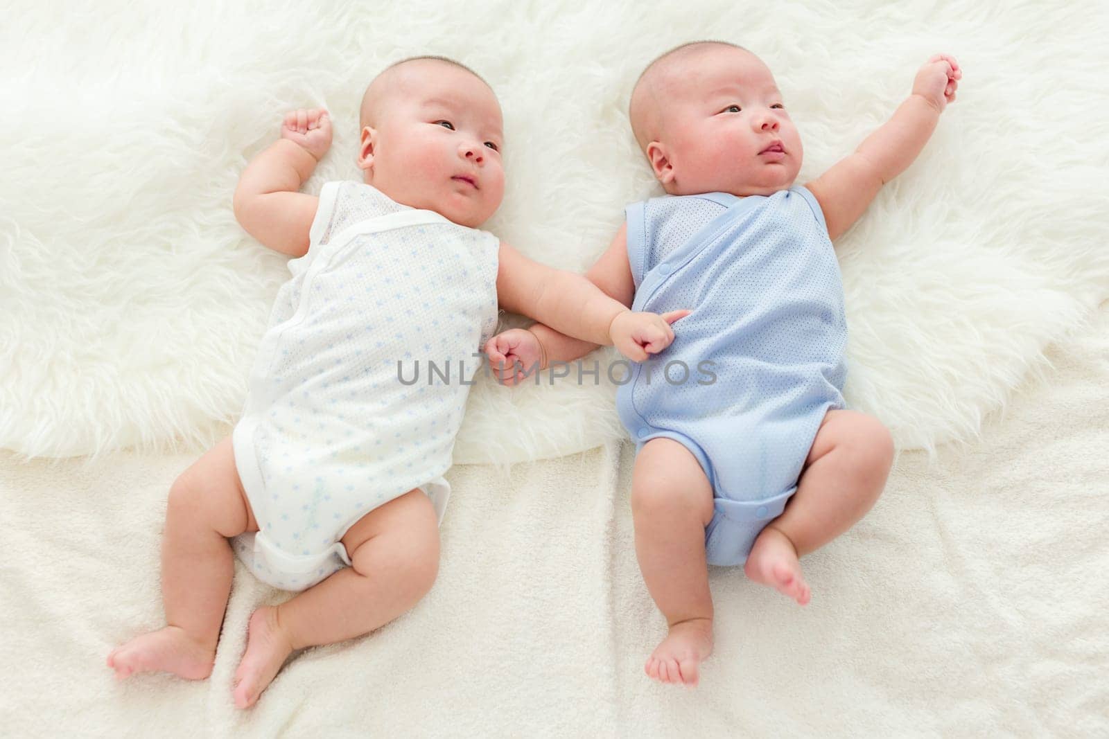 Twin babies laying on bed