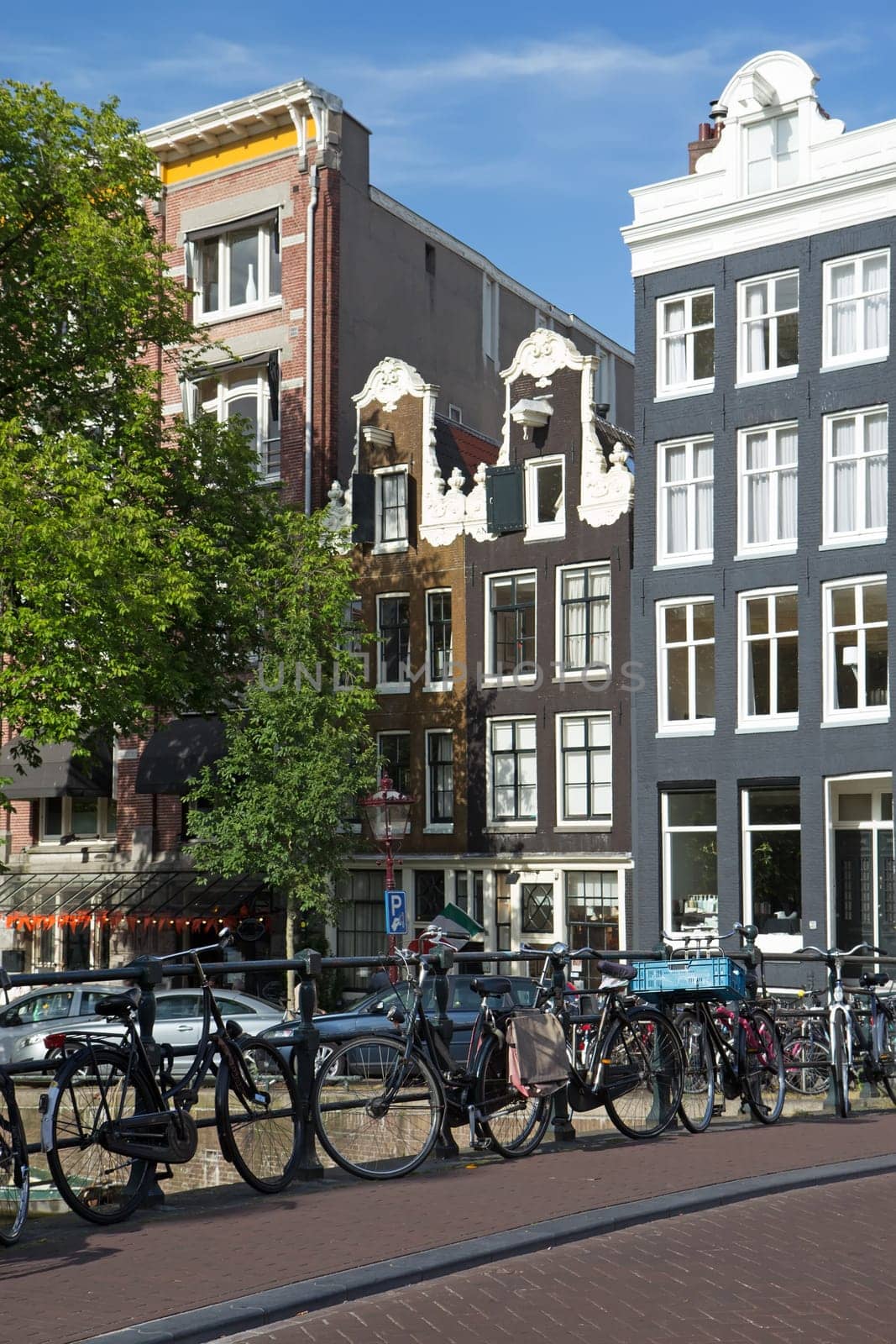 Bicycles on the bridge in Amsterdam. (Netherlands). Vertically. All potential trademarks are removed.