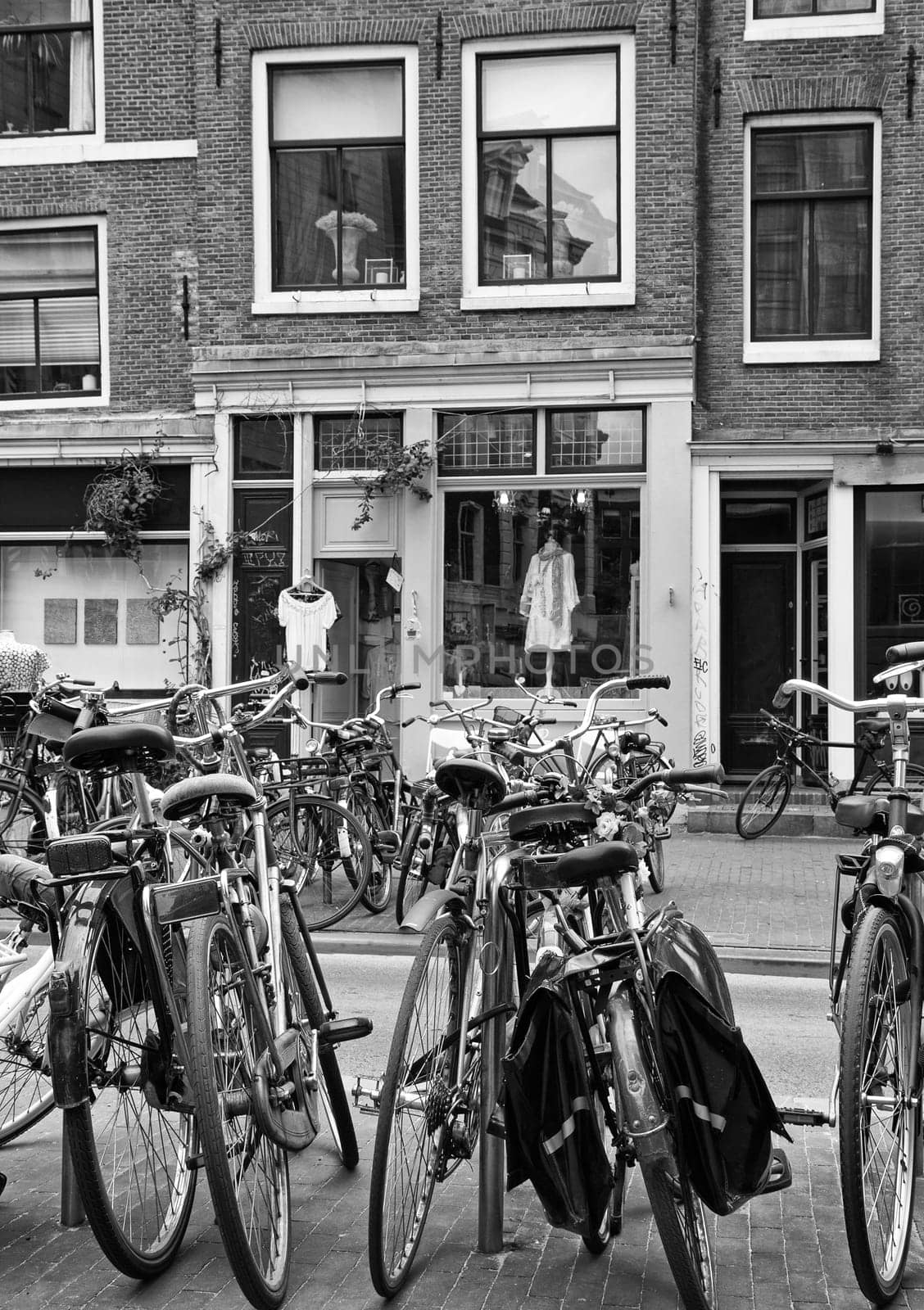 BW photo of weaned bicycle in front of houses in the center of Amsterdam.(Netherlands). All potential trademarks are removed.