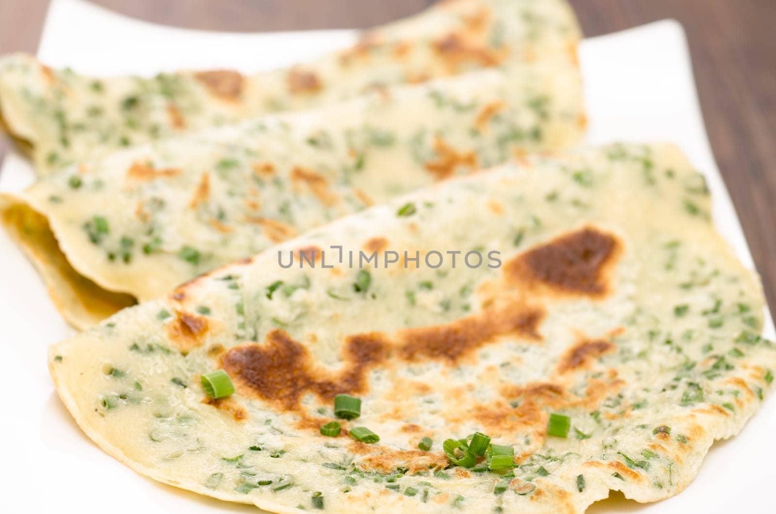 Close-up of fried egg cakes with green chids